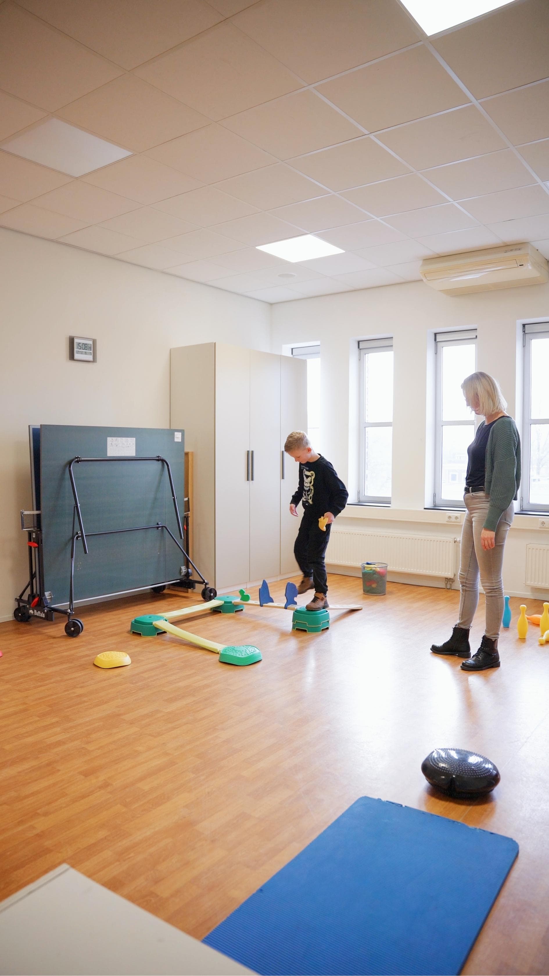 Kind aan het oefenen onder begeleiding in de oefenzaal van Fysiotherapie Bilgaard